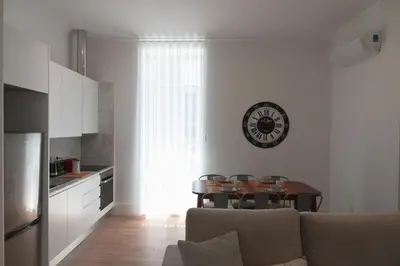 a living room with a couch and a table and a kitchen at Vibrant Host - Heroismo's Metro in Porto