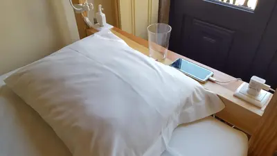 a bed with a white pillow on a wooden table at CoolHostel in Porto