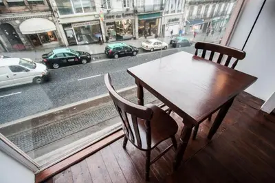 a wooden table and chairs sitting in front of a window at Linha 22 in Porto