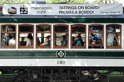 a green and white trolly train with people inside at Linha 22 in Porto