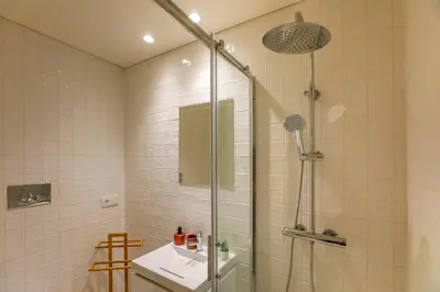 a bathroom with a shower and a sink at Oliveira Apartment`s in Porto