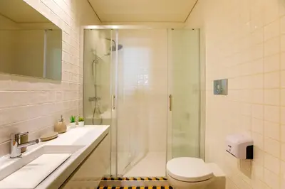 a bathroom with a shower and a toilet and a sink at Oliveira Apartment`s in Porto