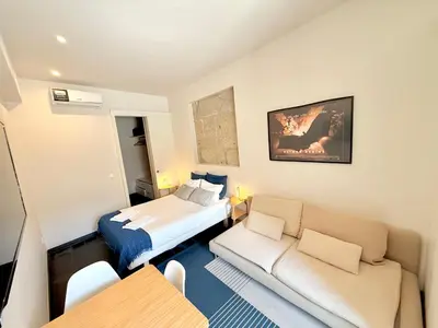 a small room with a bed and a couch at Ribeira Cinema Apartments in Porto