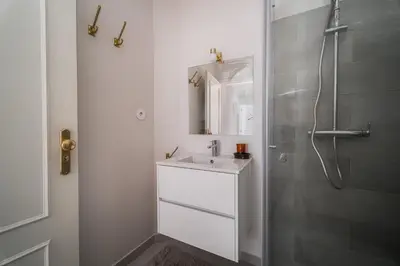 a white bathroom with a sink and a shower at Nomad's By Sta Catarina Flats - 3BED Porto in Porto