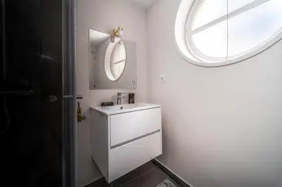 a bathroom with a white vanity and a round window at Nomad's By Sta Catarina Flats - 3BED Porto in Porto