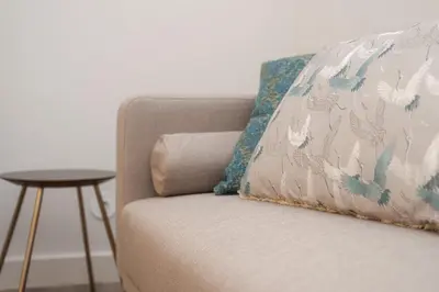 a couch with a pillow on it with a table at Nomad's By Sta Catarina Flats - 3BED Porto in Porto