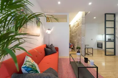 a living room with a red couch and a table at LovelyStay - Vitoria Viewpoint 1BR Flat in Porto