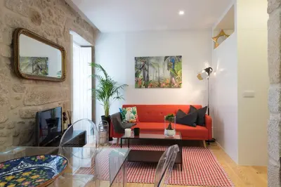 a living room with a red couch and a table at LovelyStay - Vitoria Viewpoint 1BR Flat in Porto