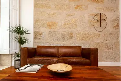 a brown leather couch in a living room with a table at Classy Belas Artes in Porto