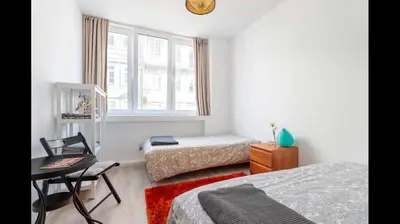 a bedroom with two beds and a desk and a window at City Heart Place 2 in Porto