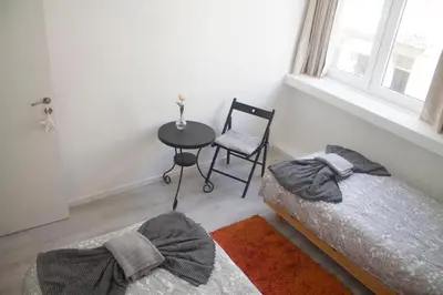 a bedroom with two beds and a table and a chair at City Heart Place 2 in Porto