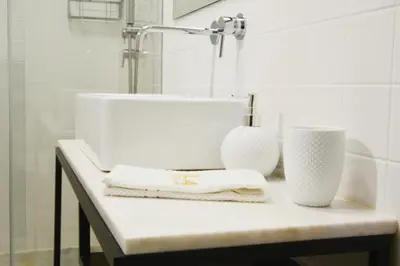 a bathroom counter with a sink and two towels at OHH - Caldeireiros Luxury Apartments in Porto
