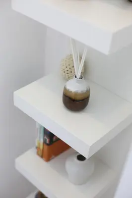 a white shelf with a vase on it at Trindade Family Apartment w/ Parking Place in Porto