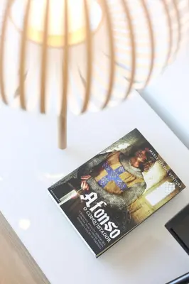 a magazine sitting on a table next to a lamp at Trindade Family Apartment w/ Parking Place in Porto