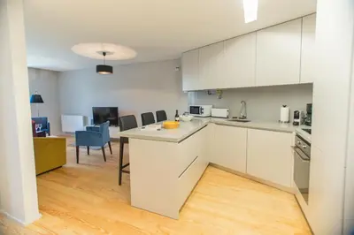 a kitchen with white cabinets and a table and chairs at Premium Style Apt by Porto City Hosts in Porto
