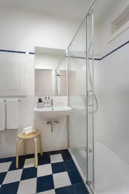 a white bathroom with a sink and a shower at FLORES PLAZA APARTMENT in Porto