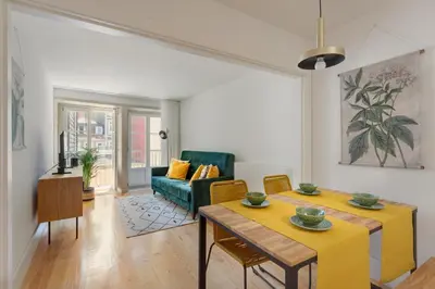 a living room with two tables and a green couch at FLORES PLAZA APARTMENT in Porto