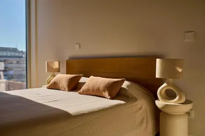 a bedroom with a bed with two lamps and a window at Oporto Maison Anselmo in Porto