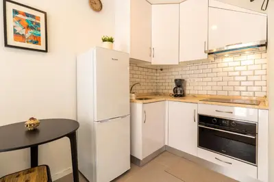 a kitchen with white cabinets and a black table at Design Boavista Music Apartments in Porto