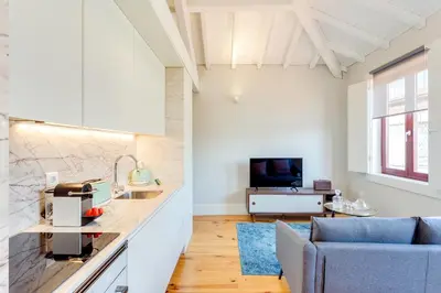 a kitchen and living room with a couch and a television at DA'HOME - Rola Art Work Studio in Porto