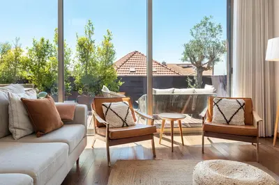 a living room with a couch and chairs and a large window at Sunny Loft in Downtown Porto with Private Parking in Porto