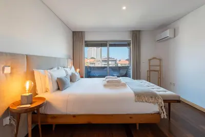 a bedroom with a large bed with a window at Sunny Loft in Downtown Porto with Private Parking in Porto