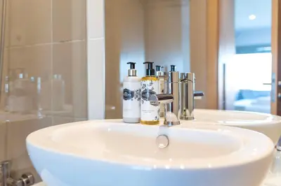 a bathroom sink with three bottles on it in front of a mirror at Sunny Loft in Downtown Porto with Private Parking in Porto
