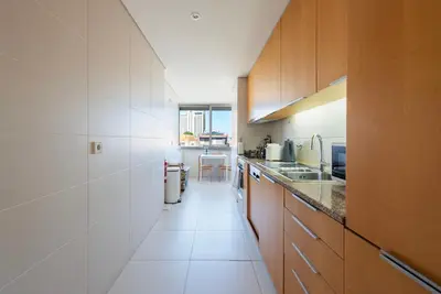 a kitchen with wooden cabinets and a long hallway at Sunny Loft in Downtown Porto with Private Parking in Porto
