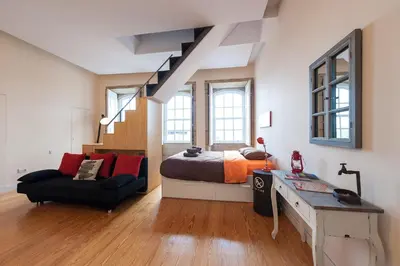 a bedroom with a bed and a desk and a chair at Studio with terrace @ historic center in Porto