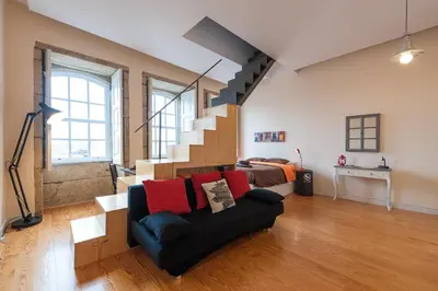 a living room with a couch and a staircase at Studio with terrace @ historic center in Porto