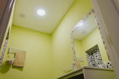a bathroom with yellow walls and a large mirror at House Romantic R/C left in Porto