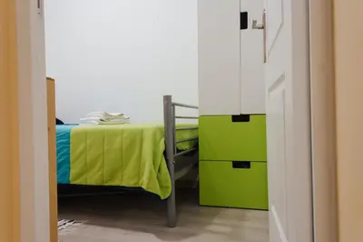 a small bedroom with a bed with a green blanket at House Romantic R/C left in Porto