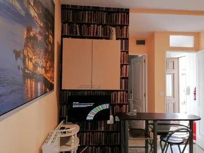 a dining room with a book shelf filled with dvds at House Romantic R/C left in Porto