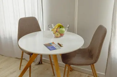 a white table with two chairs and a bowl of fruit on it at A Portuense in Porto