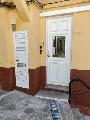 a white door on the side of a building at House Romantic R/C Right in Porto
