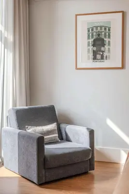 a living room with a chair and a window at Uma Formosa Apartments in Porto