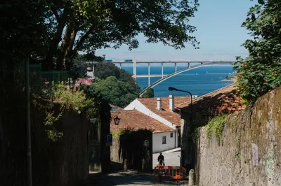 a person walking down a street with a bridge in the background at House Romantic II in Porto