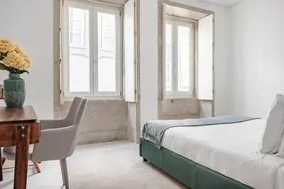 a bedroom with a bed and a desk and windows at Decompress at a Tranquil, Minimal Urban Oasis with an Edge in Porto
