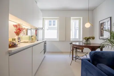 a kitchen with a table and a blue couch at Decompress at a Tranquil, Minimal Urban Oasis with an Edge in Porto