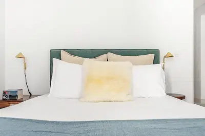 a bed with white pillows and a green headboard at Decompress at a Tranquil, Minimal Urban Oasis with an Edge in Porto