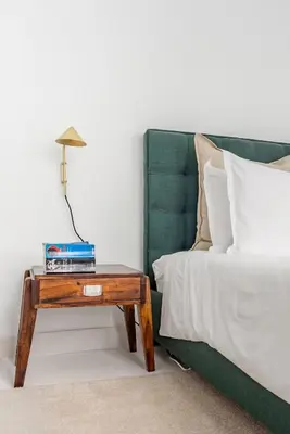 a bedroom with a bed and a table with a lamp at Decompress at a Tranquil, Minimal Urban Oasis with an Edge in Porto