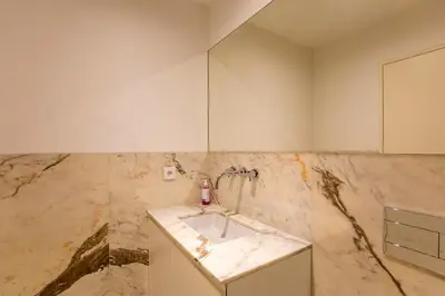 a bathroom with a sink and a marble wall at Chic Alves Apartment in Porto