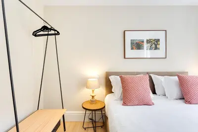 a bedroom with a bed with pink and white pillows at Jardins da Muralha Apartments by DA'HOME in Porto