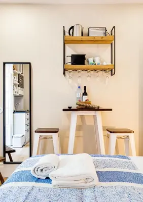 a bedroom with a bed and a table with stools at Jardins da Muralha Apartments by DA'HOME in Porto