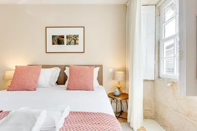 a bedroom with a bed with red and white pillows at Jardins da Muralha Apartments by DA'HOME in Porto