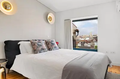 a bedroom with a large bed and a window at Rooftop Balcony at Porto Historic Center in Porto