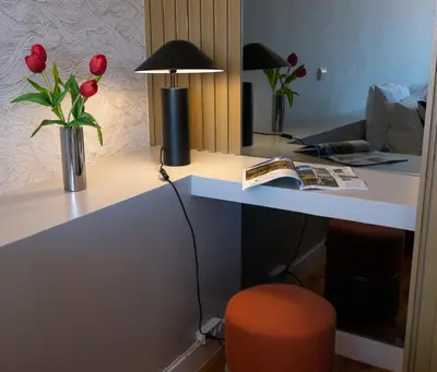 a desk with a vase of red roses and a lamp at Rooftop Balcony at Porto Historic Center in Porto