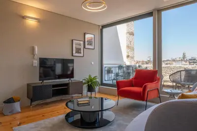 a living room with a red chair and a television at Rooftop Balcony at Porto Historic Center in Porto