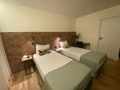 a bedroom with a bed and a desk and a chair at Hotel Portucalense in Porto