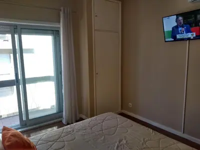 a bedroom with a bed and a tv on the wall at Alegria Downtown Apartments in Porto